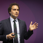 Benedetto Marelli talking on a stage with a purple background
