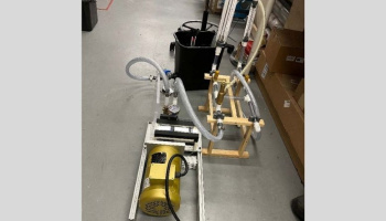 Experimental pump setup with a gold cylinder pump device with tubes coming out of it