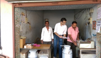Sarma speaks with local men selling milk