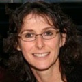 White woman with brown hair and glasses