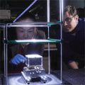 Researchers standing around glass box prototype